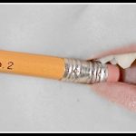 closeup picture of someone chewing the erasure of a pencil labeled "Integrity #2"
